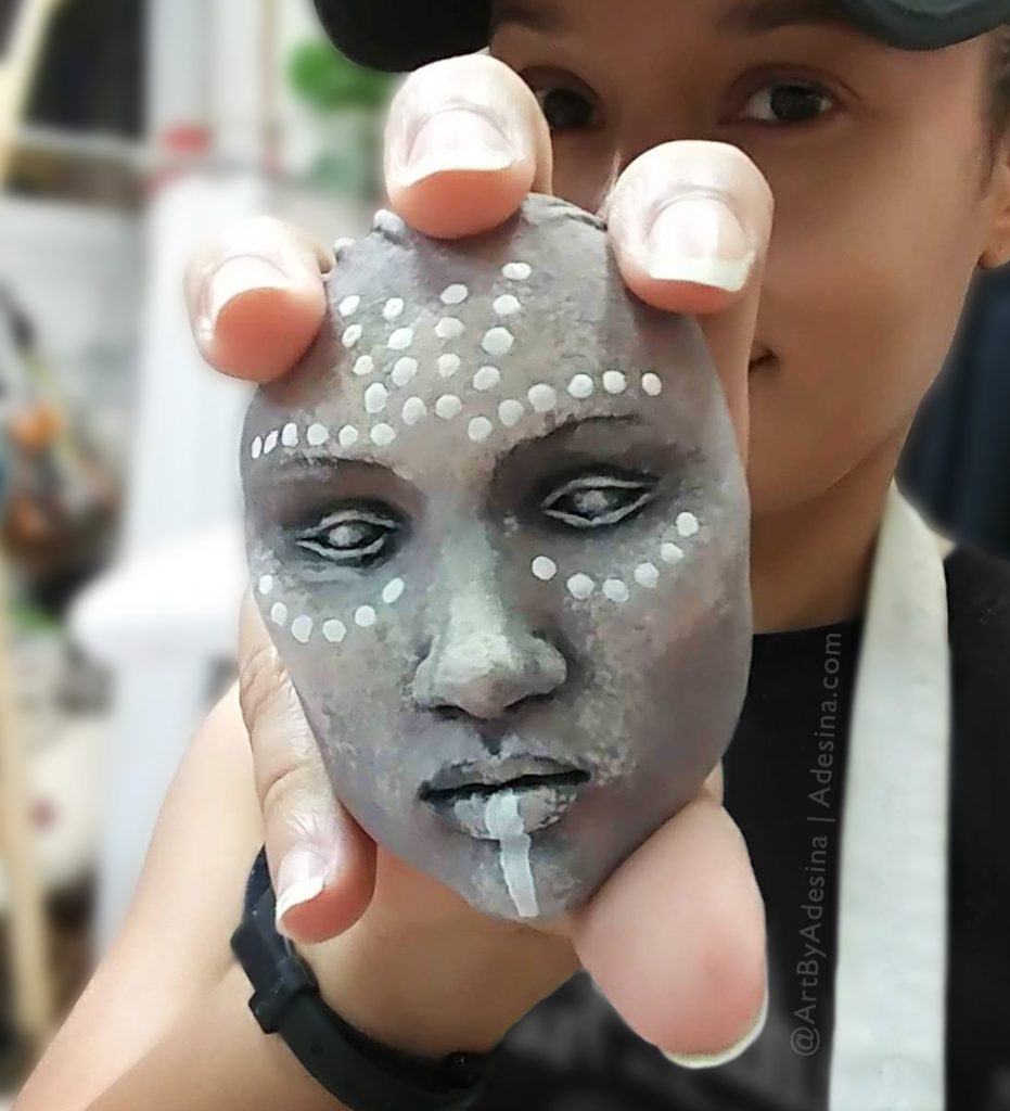 Photo of artist Adesina Sanchez and her ceramic Wakanda mini mask