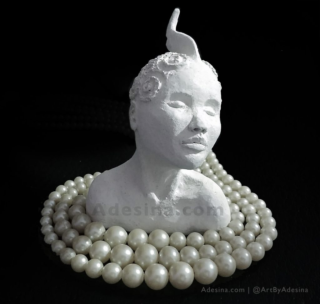 Photo of Adesina Sanchez's unglazed ceramic goddess sculpture, with a pearl necklace.